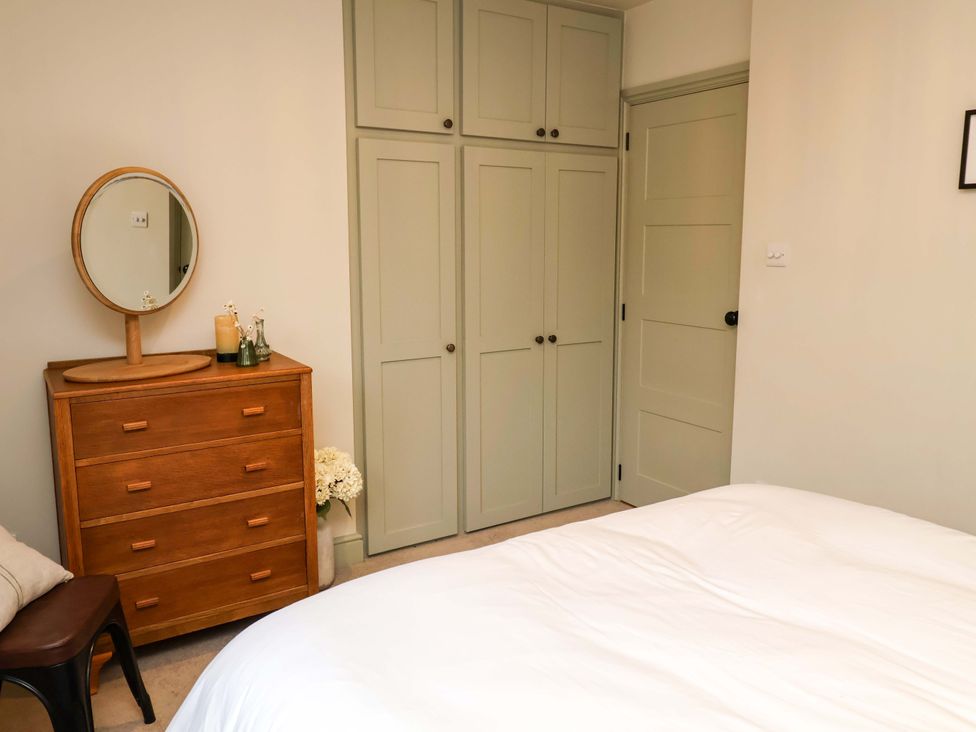 A bedroom with a dresser and mirror at Fairview in Darsham