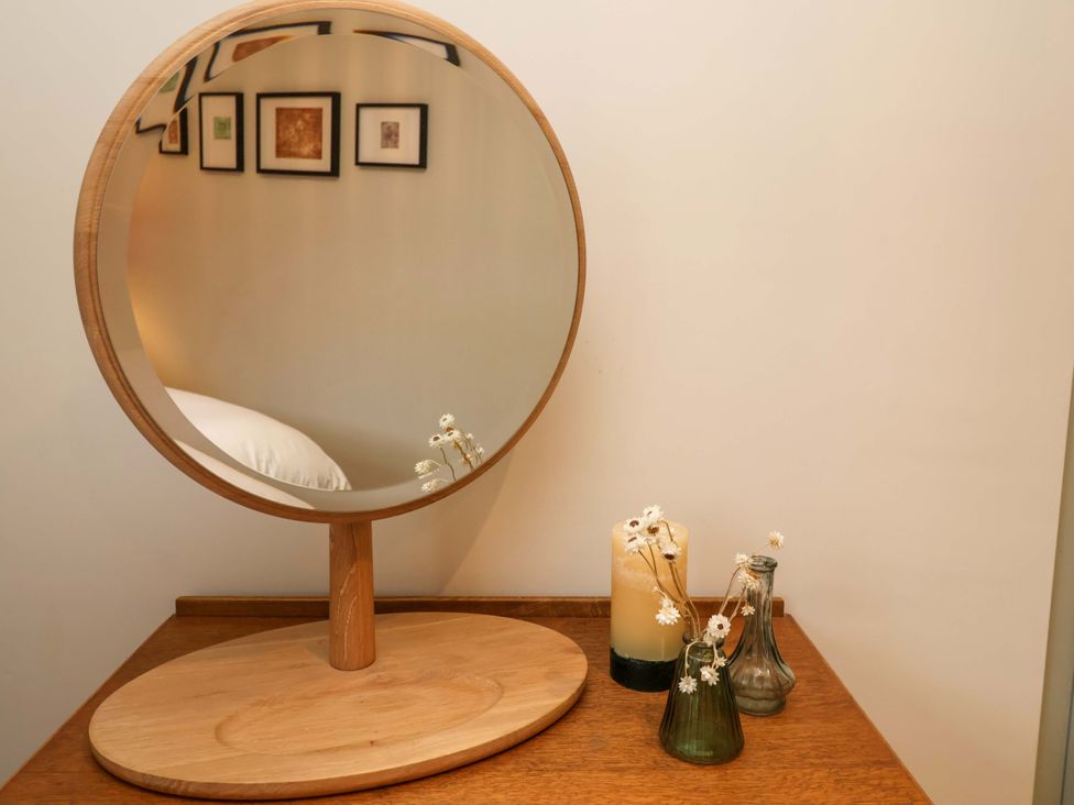 A mirror and decorative items on a wooden surface at Fairview in Darsham