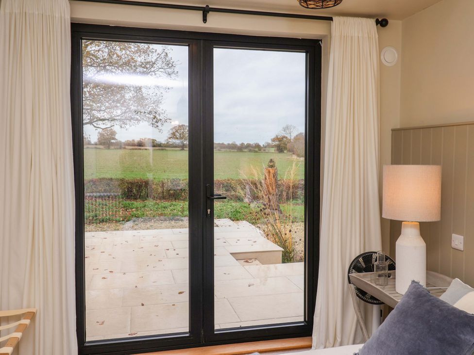 A bedroom with a sliding door leading to an outdoor area at Fairview in Darsham