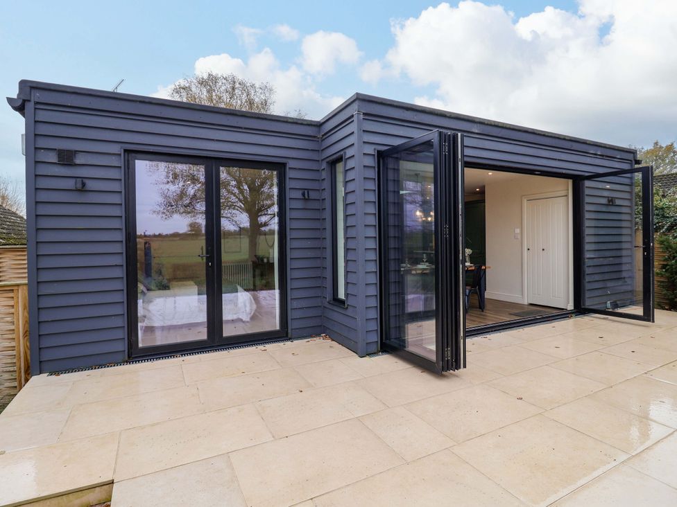 An outdoor space with sliding doors and patio tiles at Fairview in Darsham