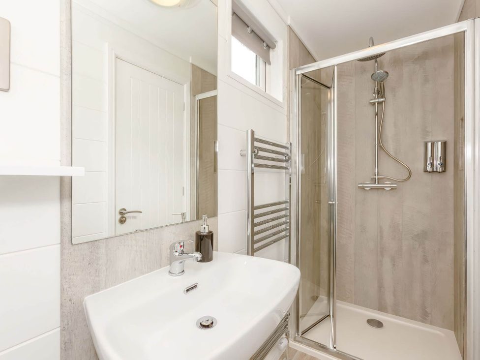 A bathroom with a shower and sink at The Falls (Pet) in Leyburn