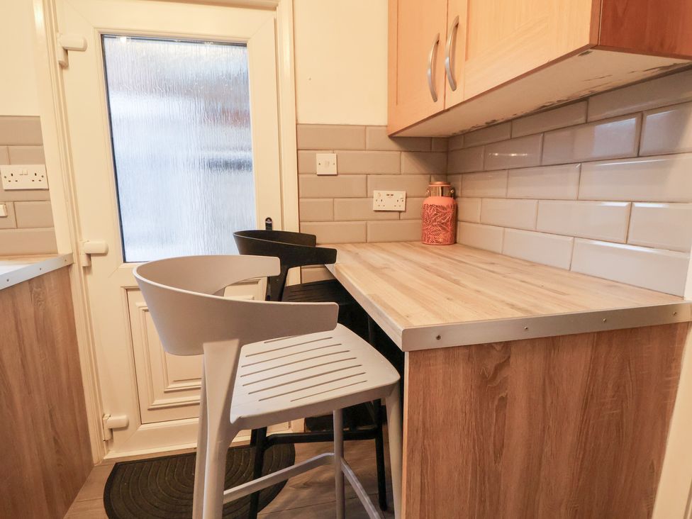 A kitchen counter with bar stools and a door at 50 Gladstone Avenue in Chester