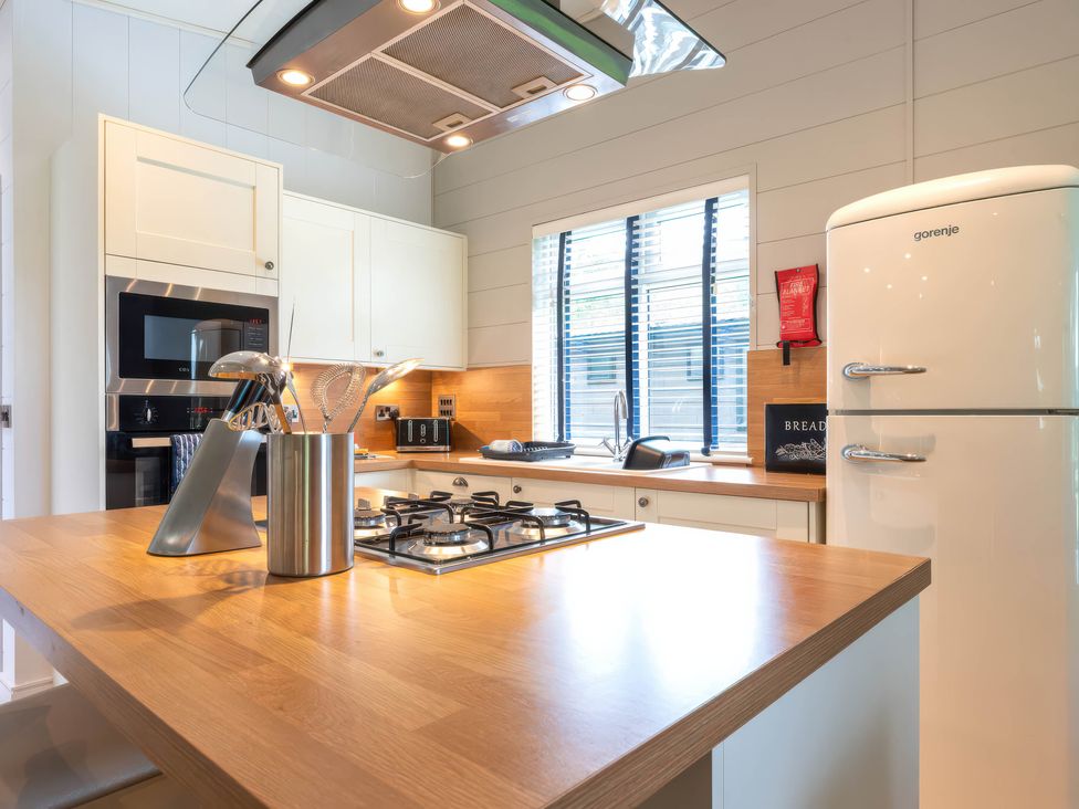 A kitchen with a gas stove and fridge at Bainbridge in Leyburn