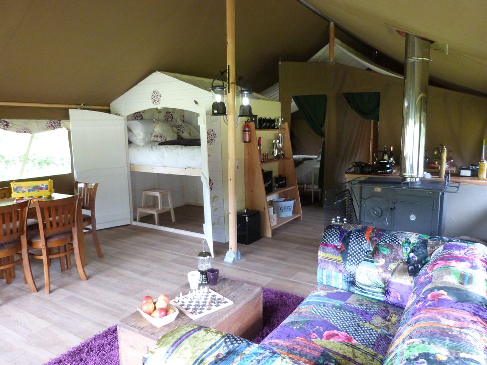 An indoor living space with a sofa, table, and kitchen area at Aeron in Newcastle Emlyn