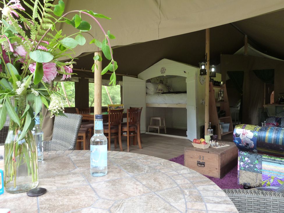 A dining area with a vase of flowers and a mounted bed at Aeron in Newcastle Emlyn