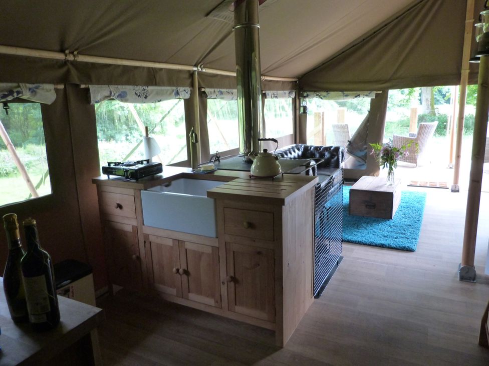 A kitchen with a sink and stove in a tent at Teifi Newcastle Emlyn