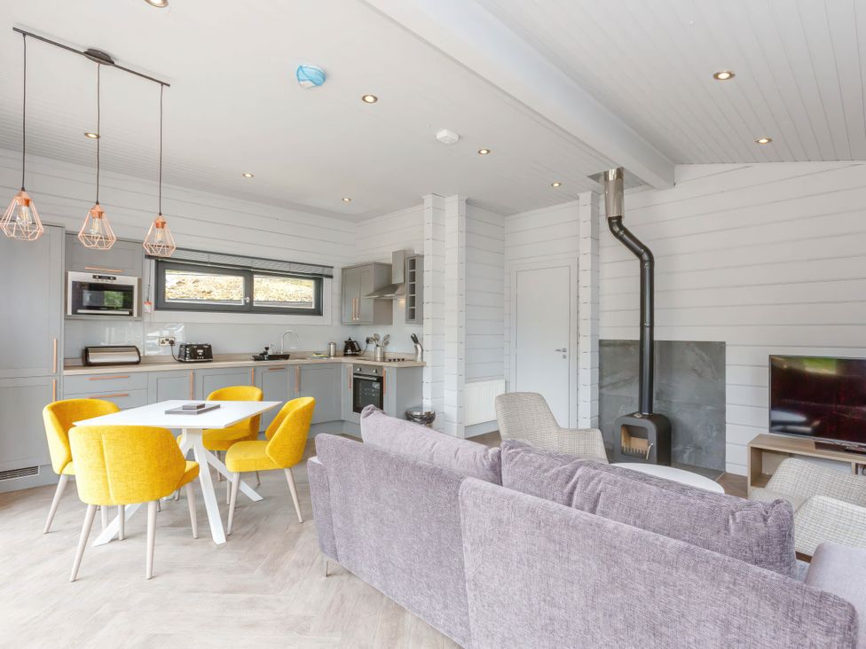 A kitchen and living room with a dining table and sofa at Leyburn