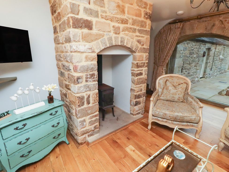 A living room with a fireplace and a chair at The French