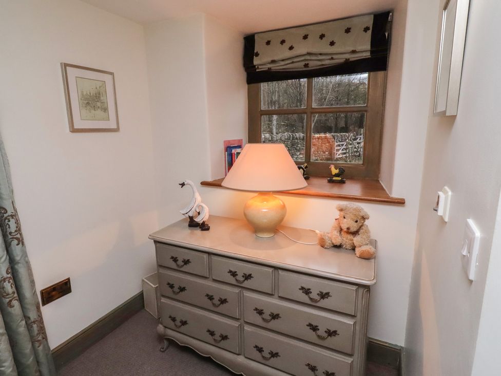 A bedroom with a dresser and lamp with a window at The French in 