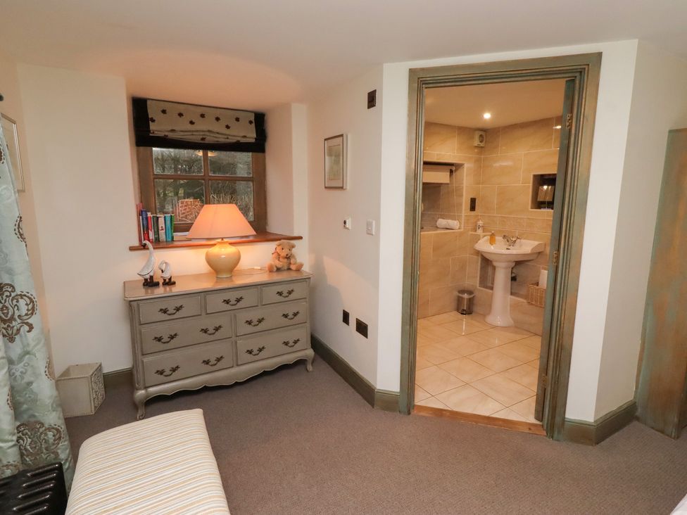 A bedroom with a dresser and a bathroom entrance at The French in 