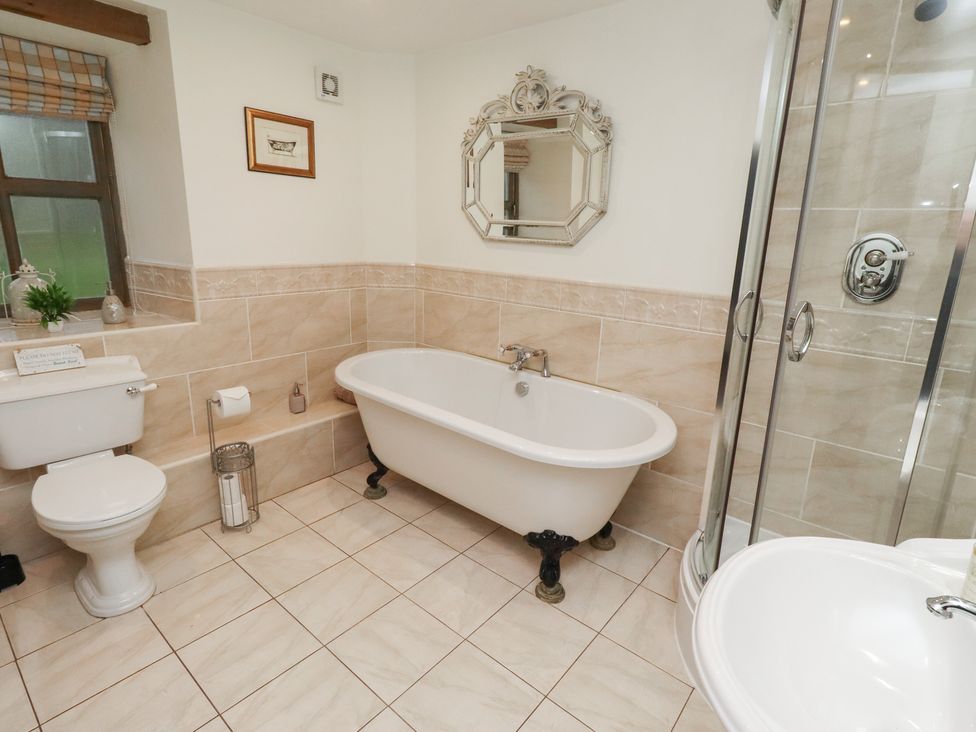 A bathroom with bathtub, toilet, sink and shower enclosure at The French
