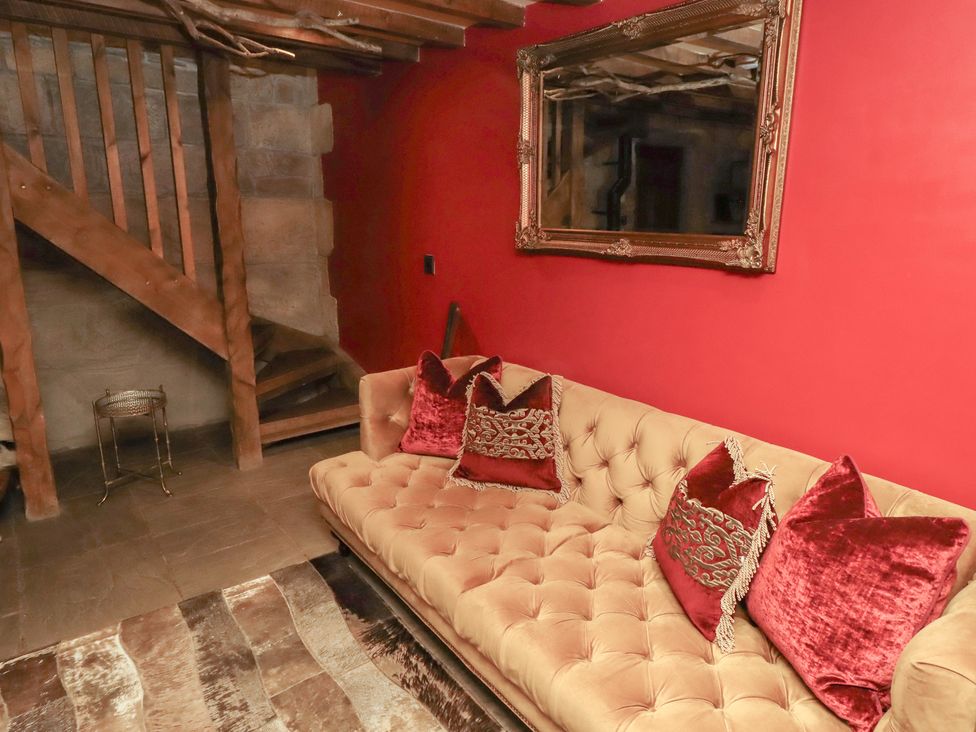 A living room with a sofa and staircase at The Medieval Romantic