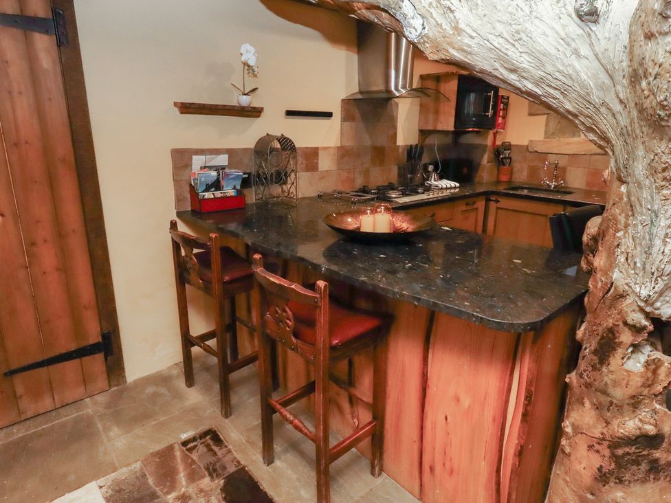 A kitchen with a countertop and bar stools at The Medieval Romantic in 