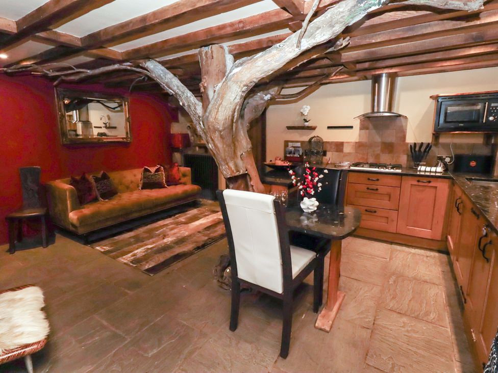 A living room with a tree branch and kitchen units at The Medieval Romantic