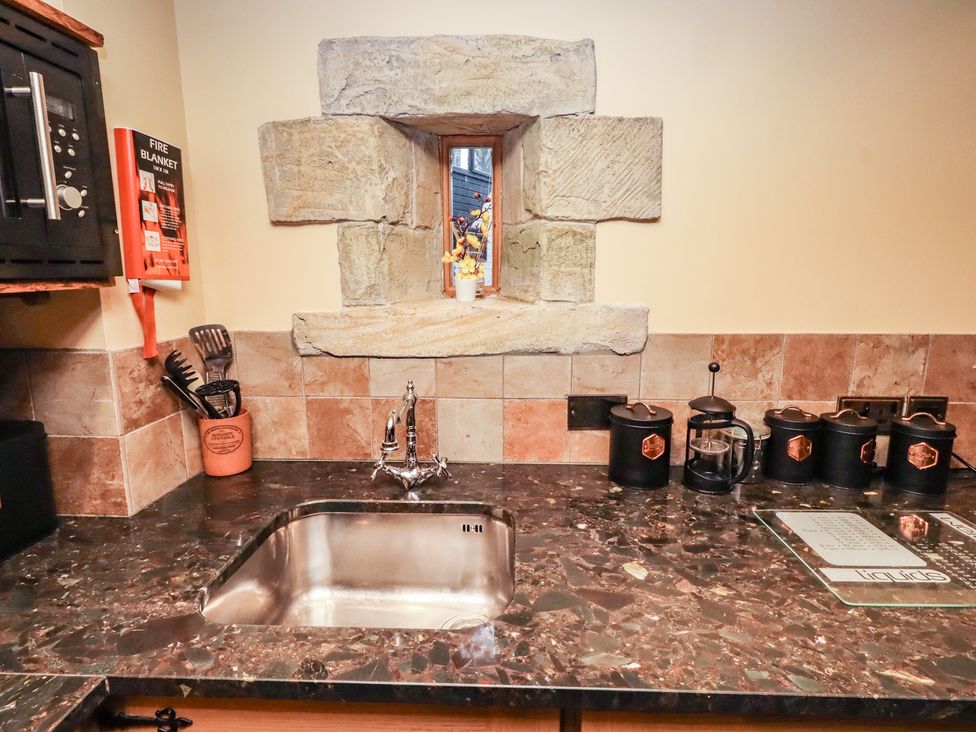A kitchen with a sink and stone window at The Medieval Romantic 