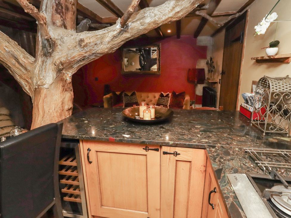 A kitchen with a tree and bar counter at The Medieval Romantic in 