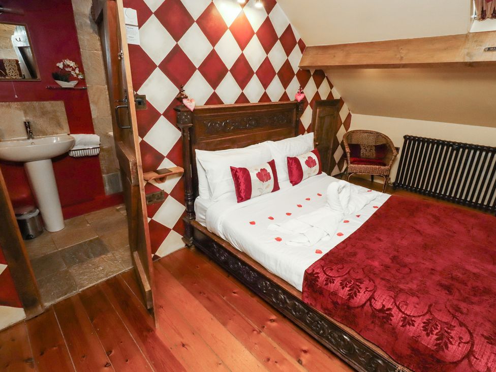 A bedroom with a bed and attached bathroom at The Medieval Romantic