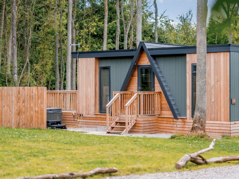 A cabin with wooden deck and steps at Tennyson Spa in Louth