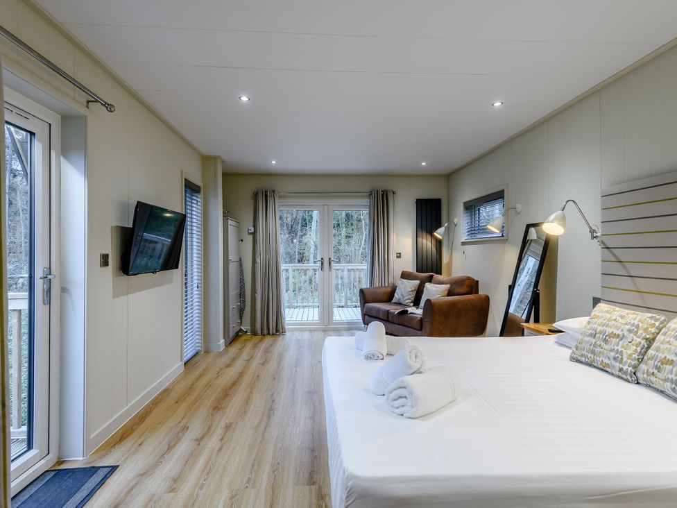 A bedroom with a bed and sofa at Tennyson Spa in Louth