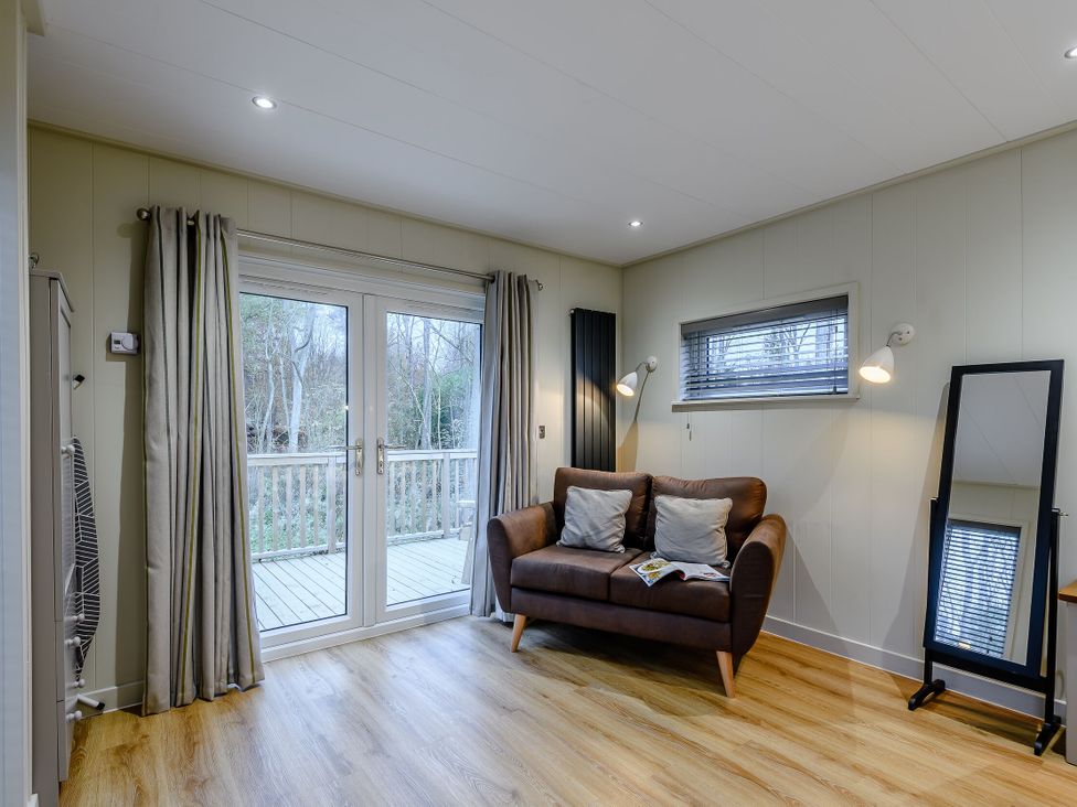 A living room with a sofa and large window at Tennyson Spa in Louth