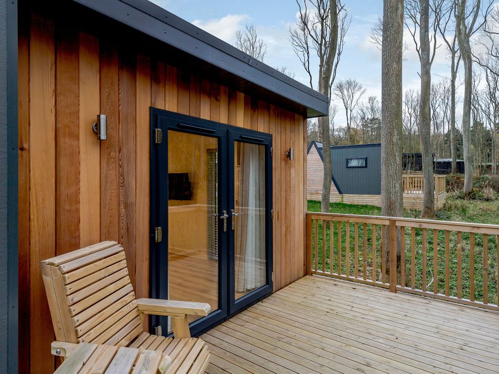 An outdoor area with a wooden deck and chair at Tennyson Spa Louth