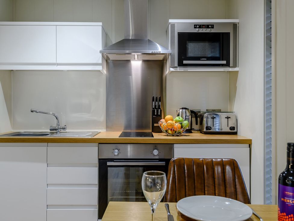 A kitchen with appliances including a microwave and oven at Tennyson Spa (Pet) Louth