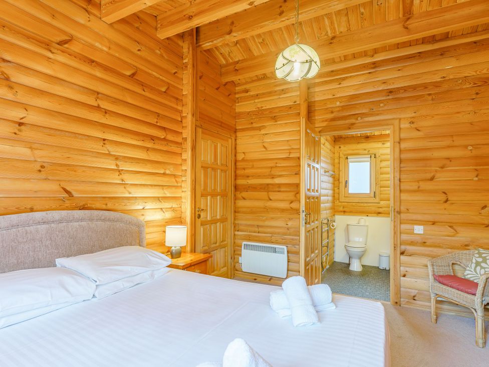 A bedroom with a bed and bathroom door at Maple Lodge in Louth