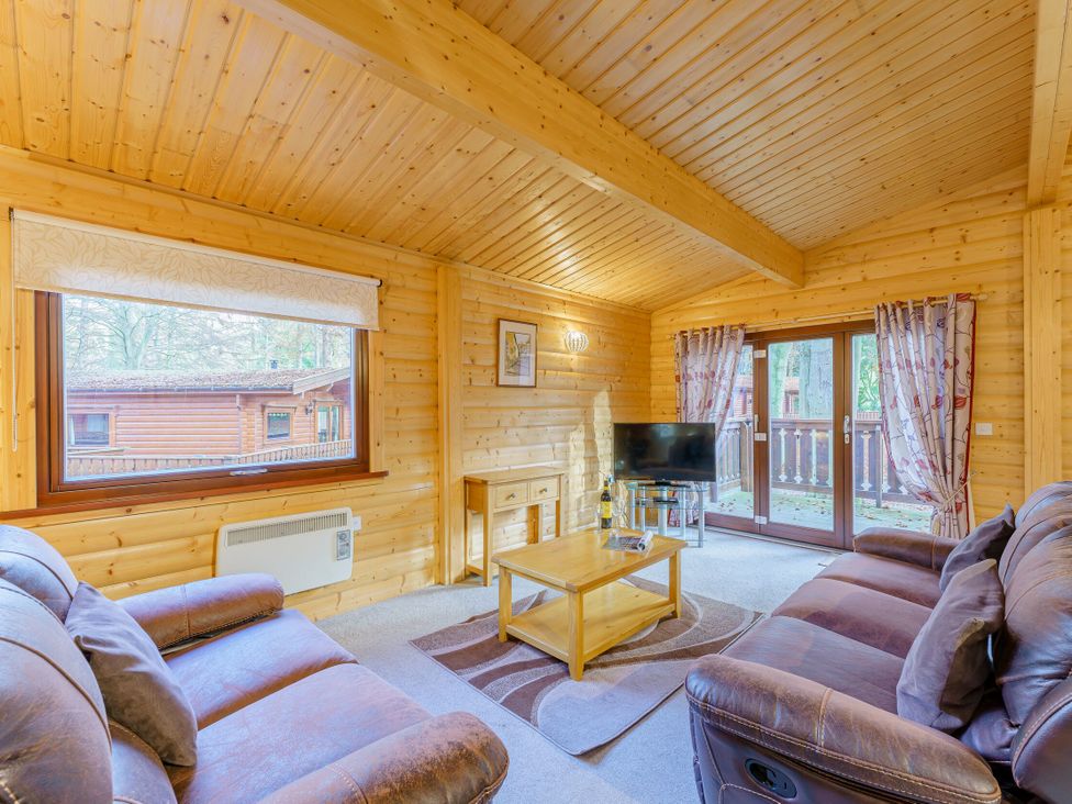 A living room with a sofa and coffee table at Maple Lodge in Louth