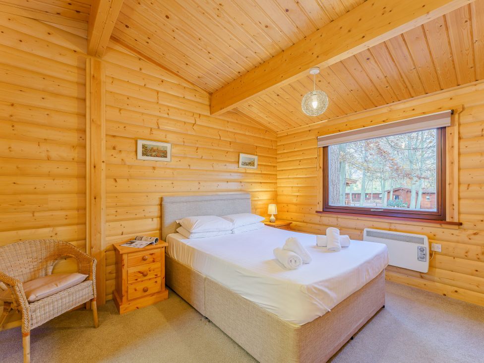 A bedroom with a bed and window at Maple Lodge in Louth