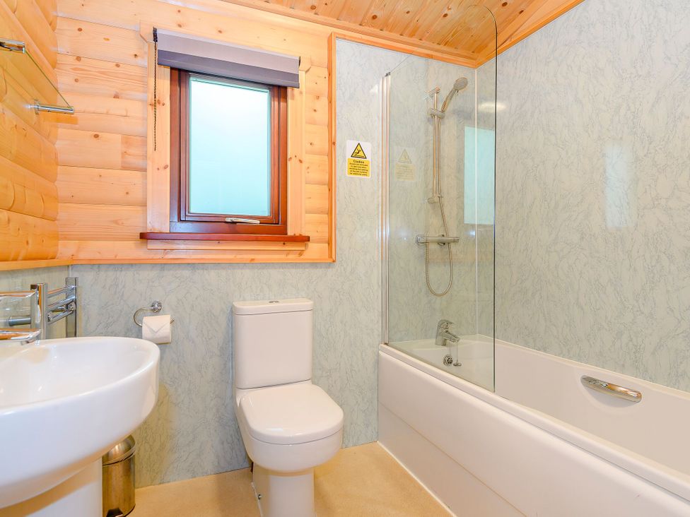 A bathroom with a sink, toilet, bathtub, and shower at Maple Lodge in Louth