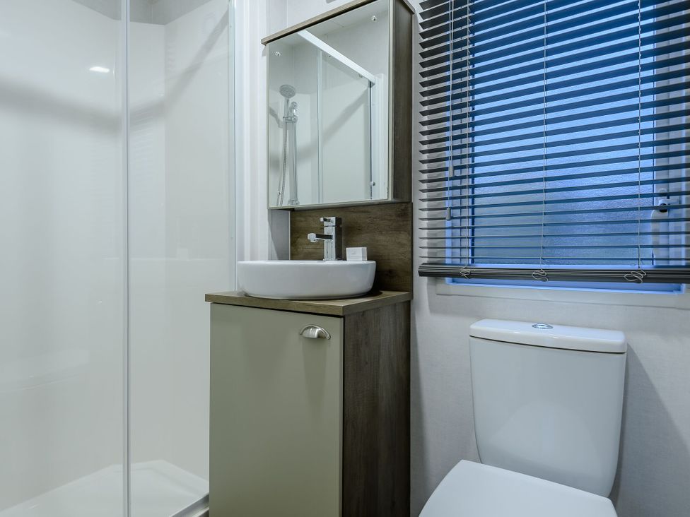 A bathroom with a shower, sink, and toilet at Anderby Spa (Pet) Louth