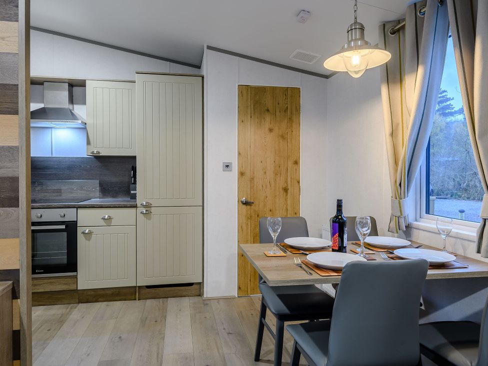 A dining room with a table and kitchen cabinets at Anderby Spa (Pet) Louth