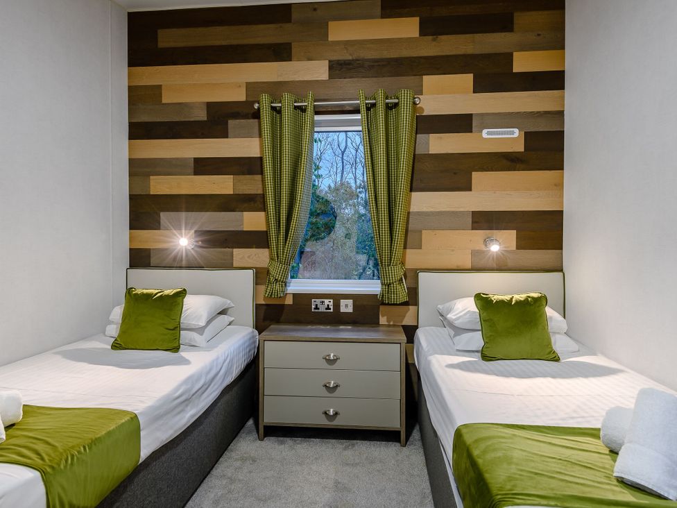A bedroom with two single beds and a window at Anderby Spa (Pet) Louth
