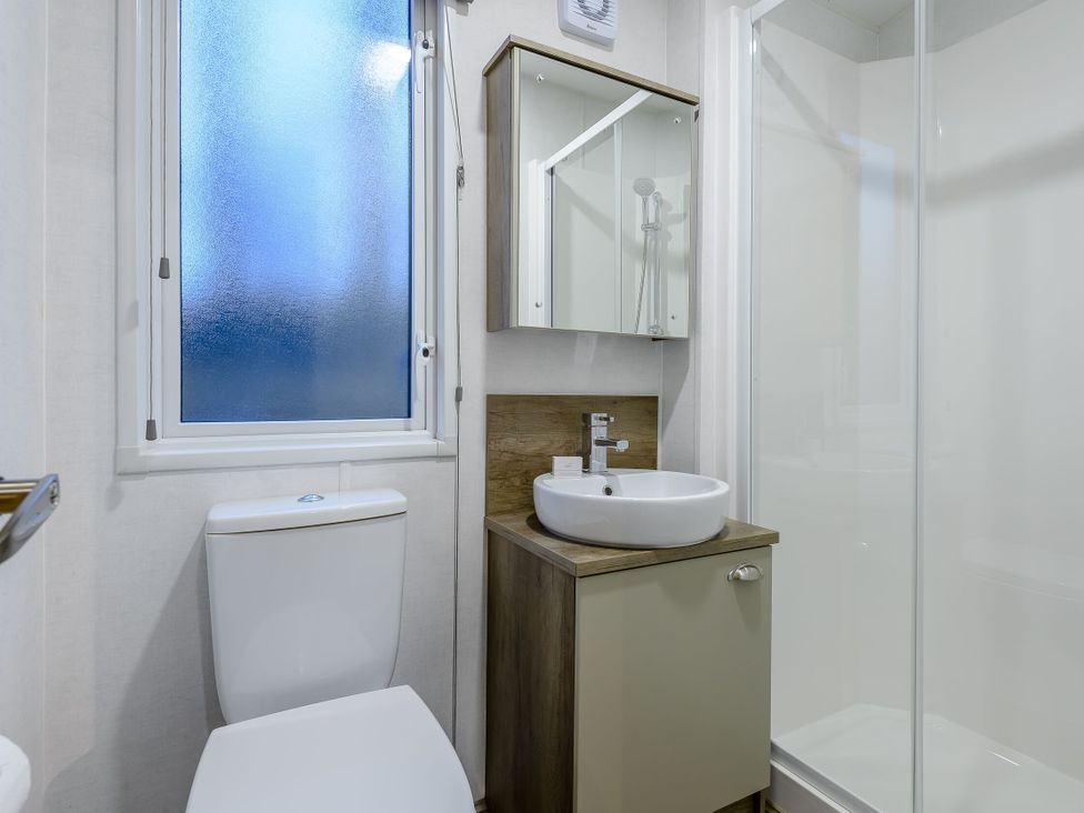A bathroom with a sink toilet and shower at Anderby Spa (Pet) Louth