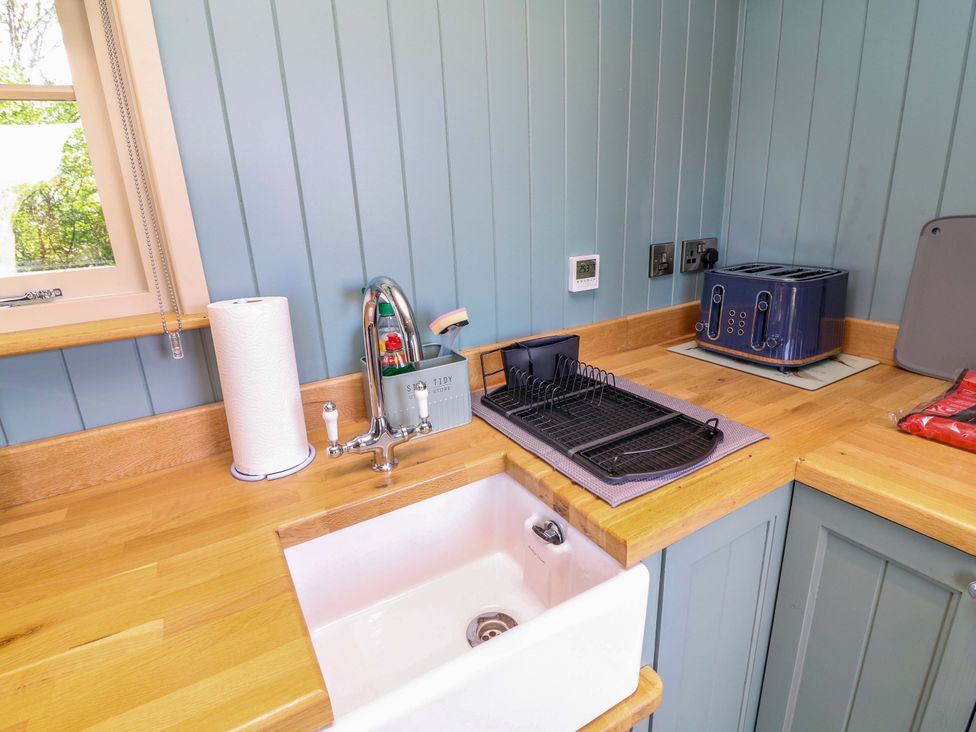 A kitchen counter with a sink and toaster at Kingfisher Hut