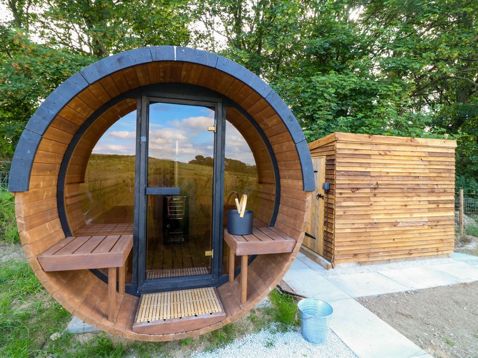 A wooden hot tub with benches outside in an outdoor area at Kingfisher Hut