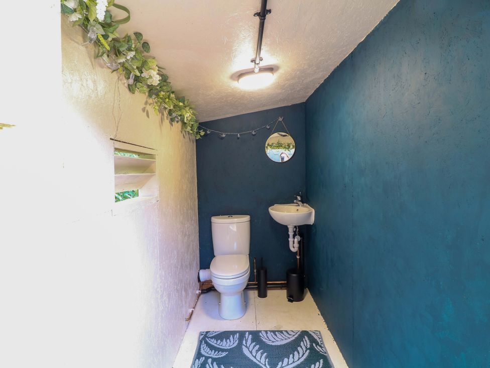A bathroom with toilet and sink at Kingfisher Hut