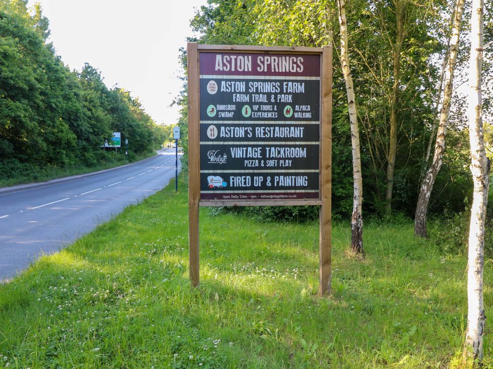 A sign for Aston Springs with attractions listed next to a road