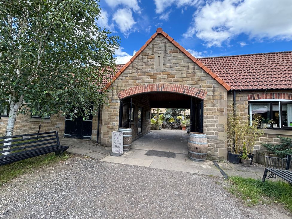 An outdoor entrance with a bench and barrel at Kingfisher Hut Swallownest near Sheffield