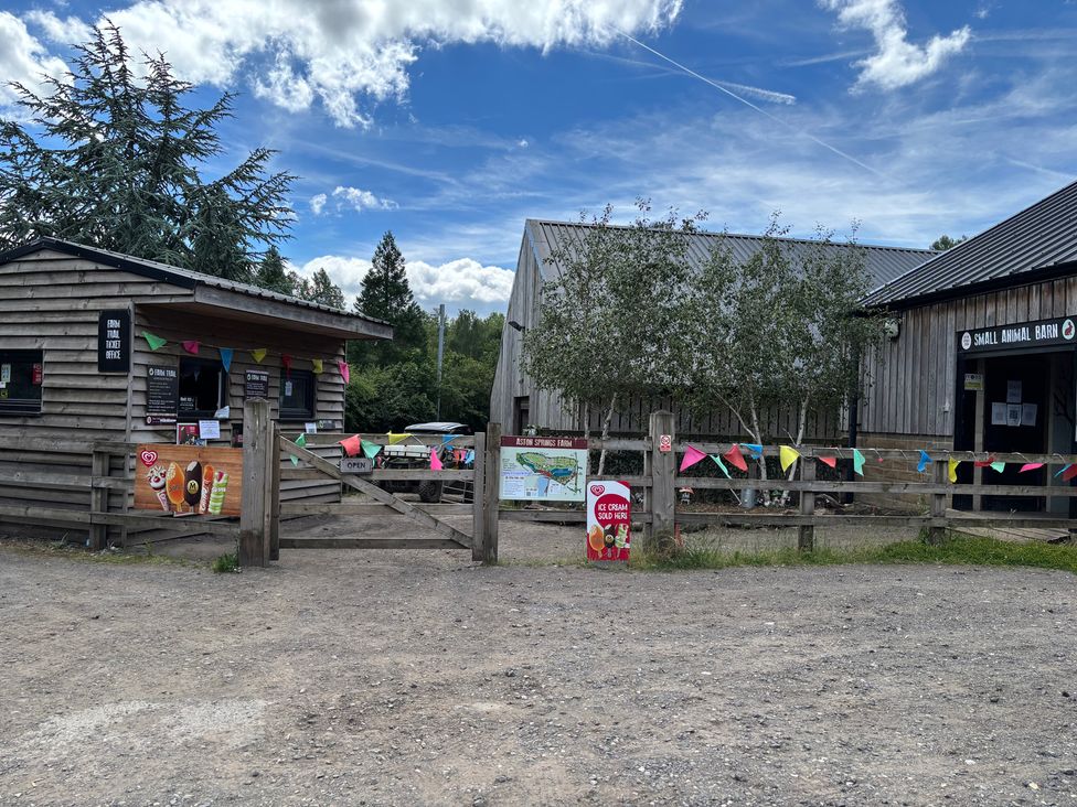 An outdoor area with a ticket office and small animal barn at Aiston Springs Farm in England