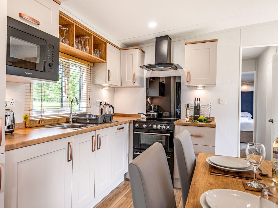 A kitchen with sink, oven, and microwave at Caistor Spa in Louth