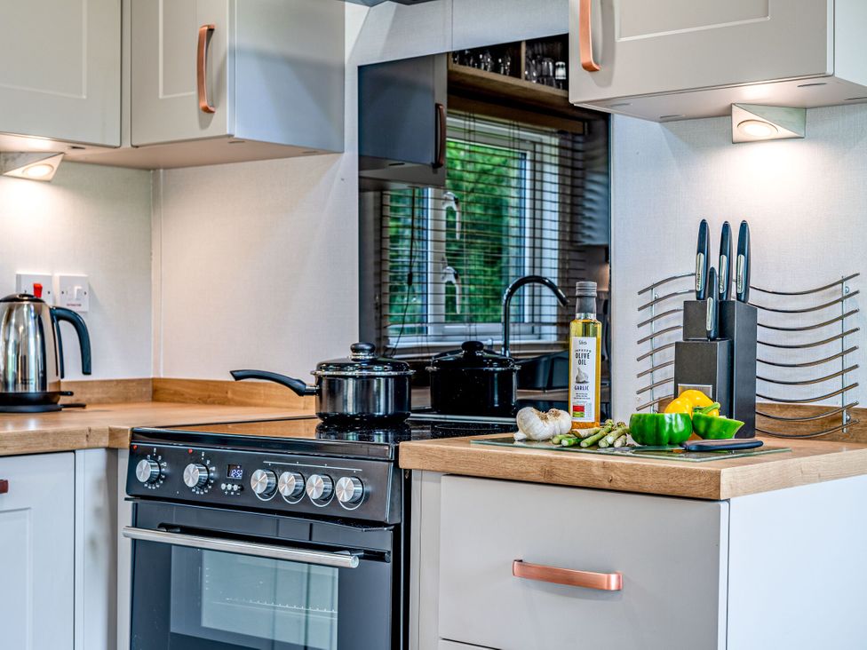 A kitchen with a stove, kettle, pots, and vegetables at Caistor Spa in Louth