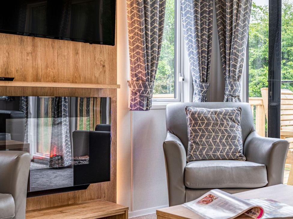 A living room with a television and a chair at Caistor Spa in Louth