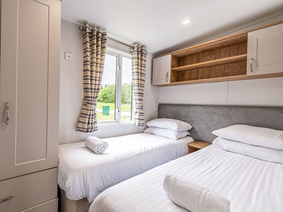 A bedroom with two single beds and a window at Caistor Spa in Louth
