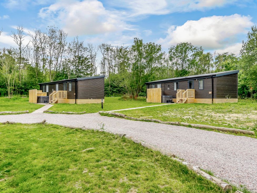 Two lodges with a pathway in an outdoor area at Horncastle Plus in Louth