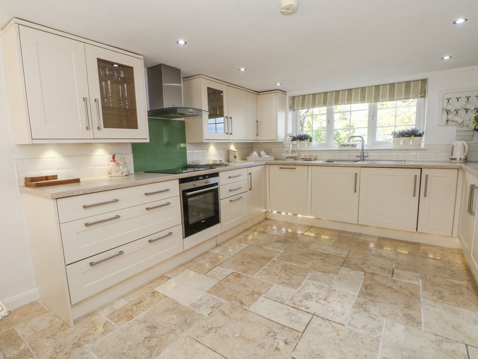 A kitchen with cabinets and appliances at Curlew Cottage in Lower Peover, Cheshire