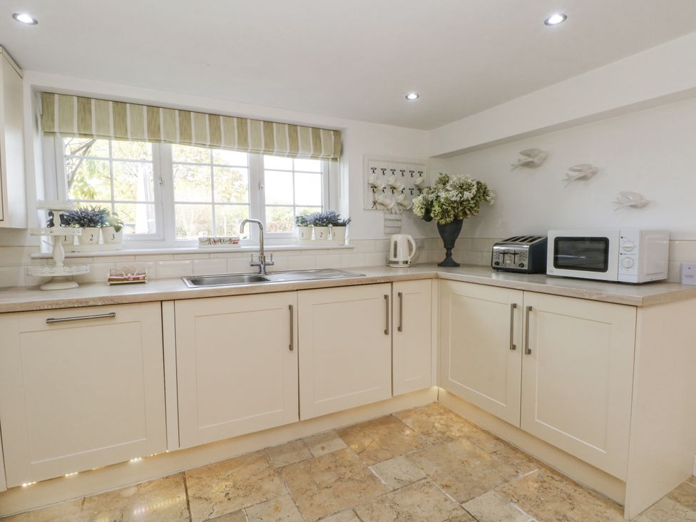 A kitchen with a sink and appliances at Curlew Cottage in Lower Peover, Cheshire