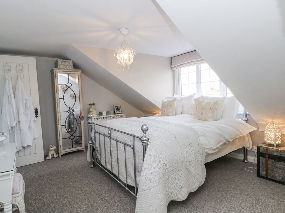 A bedroom with a bed and a mirror at Curlew Cottage in Lower Peover, Cheshire