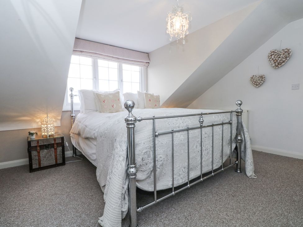A bedroom with a bed and lamp at Curlew Cottage in Lower Peover, Cheshire