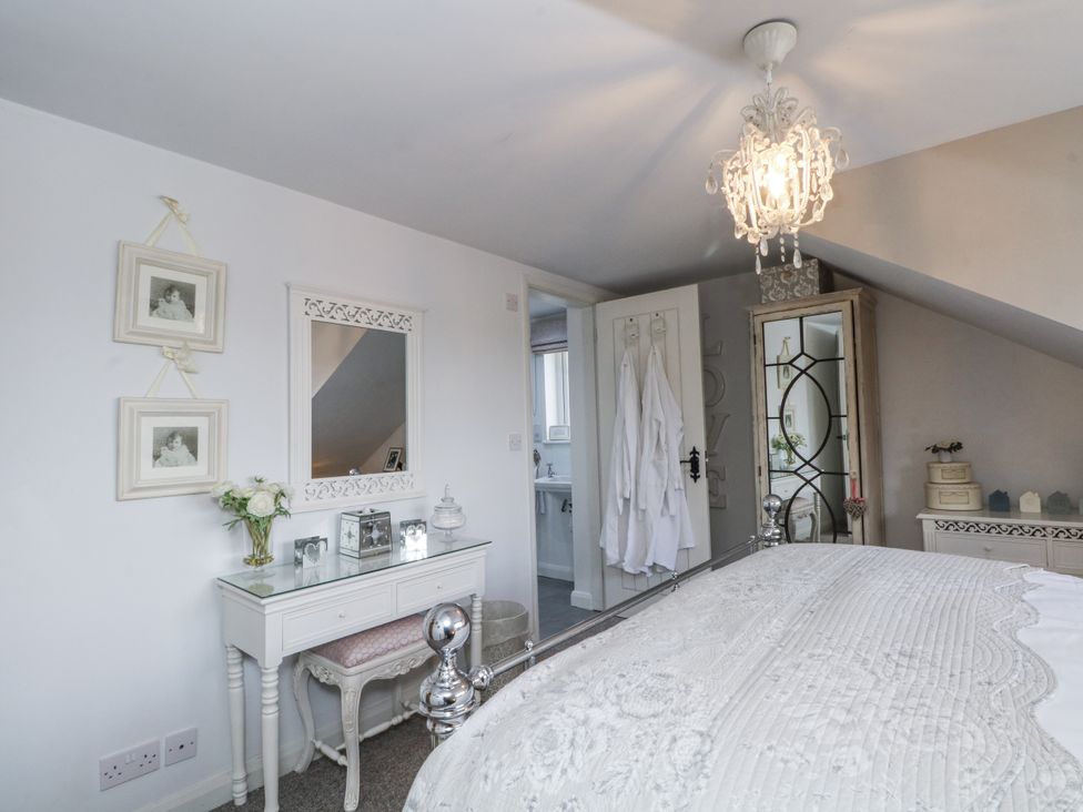 A bedroom with a bed and dressing table at Curlew Cottage in Lower Peover, Cheshire